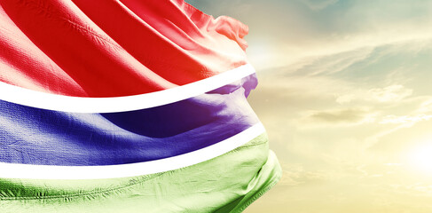 The Gambia national flag waving in the sky.