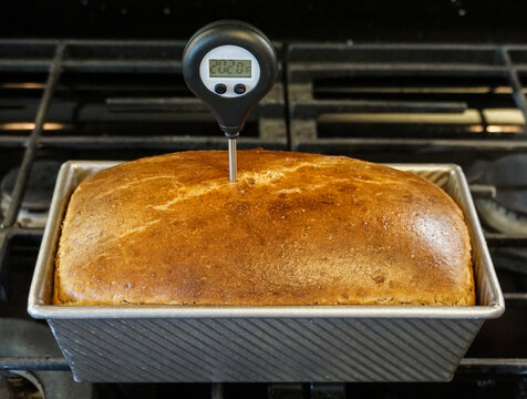 A bread thermometer, an essential baking tool, indicates the interior temperature of a loaf to determine when the bread can come out of the oven.
