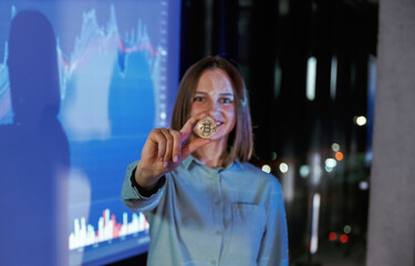 Positive female is with digital currency coin. Businesswoman is against projector with graphs,...