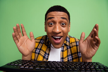 Photo of funky impressed guy raise arms open mouth unexpected reaction computer keyboard isolated...