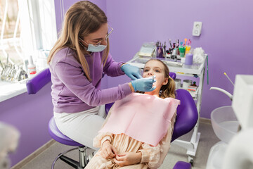 dentist examining a girl's teeth