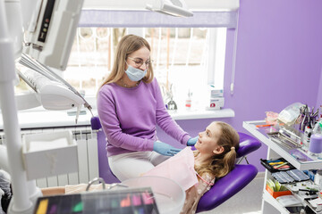 dentist smiling at his girl patient, pediatric dentistry