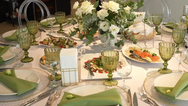 a table set for a dinner party with plates , glasses , napkins and flowers