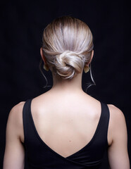 Female in black t-shirt with bun hairdo. Back view portrait of young blonde woman. - 773201935