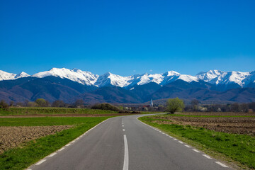 Landscape with Fagaras mountains with snowy peaks. Carpathian mountains seen in spring in Romania