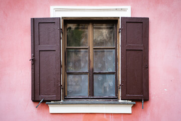 Idyllisches Fenster mit dunklen Fensterläden und Rosafarbener Fassade in Krumau Tschechien