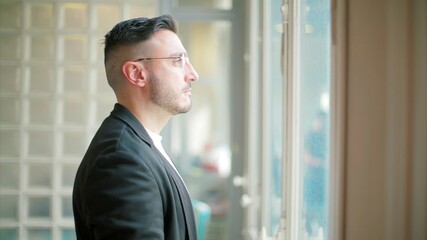 Fototapeta premium Pensive man by glass block window