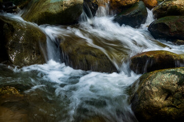Fototapeta na wymiar Long exposure image of stream water with rocks