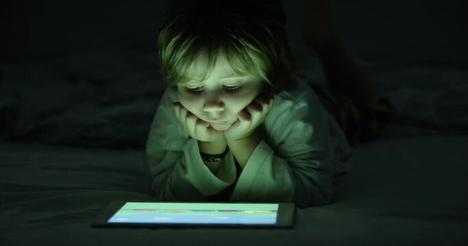 Boy enjoy digital tablet at night