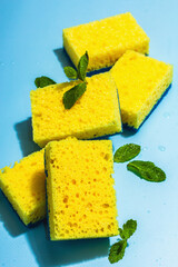 Bright yellow sponges for washing dishes. Organic cleaning concept, minty freshness