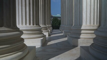 Very large towering columns in front of US Supreme Court building in Washington, DC showing...