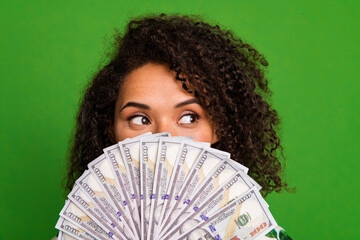 Photo of dreamy cunning lady wear print shirt money fan cover face looking empty space isolated green color background