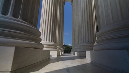 Very large towering columns in front of US Supreme Court building in Washington, DC showing judicial power over people and business.