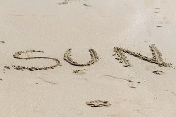 Inscription sun soleil écrit dans le sable