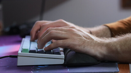 A man working from home and typing on a computer keyboard