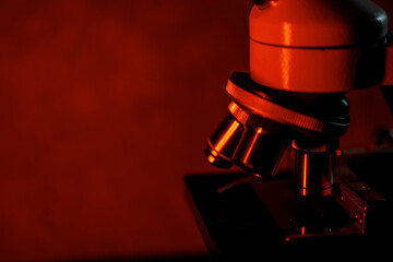 Medical microscope lenses close up, In warm red lighting