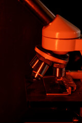Medical microscope lenses close up, In warm red lighting