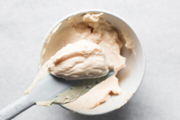 Top view of orange buttercream for decorating cake, silky smooth american buttercream on a spatula, overhead view of smooth buttercream