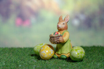 A statue of a rabbit holding colored Easter eggs. Easter, Pascha or Resurrection Sunday concept