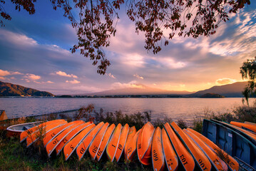 Mt. Fuji over Lake Kawaguchiko with boats at sunset in Fujikawaguchiko, Japan.