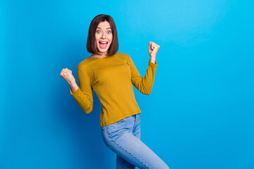 Photo of positive lucky lady dressed shirt yelling yes rising fists empty space isolated blue color...