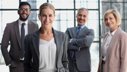 business woman with crossed arms against the background of a business team