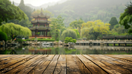 An empty wooden table top, with a Chinese zen garden, complete with a tranquil pond and historic temple, gently blurred in the background