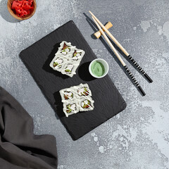 Vegetable and cheese sushi rolls on a slate with a contemporary presentation, perfect for modern Japanese cuisine