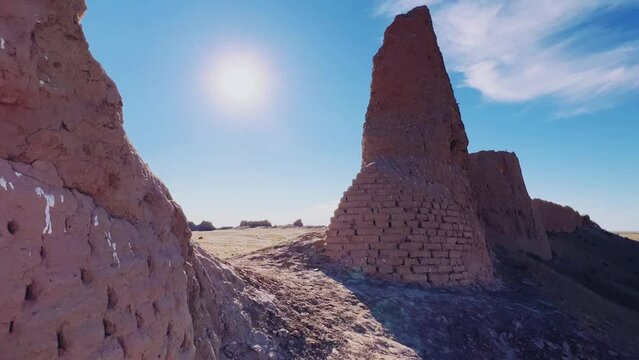 Turkestan walls of the ancient city of Sauran on a sunny day with a blue sky. Ancient buildings, fortress, ruins, ancient architecture in the settlement of Sauran. Archaeological excavations.