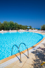 Swimming pool on sunny day by sea