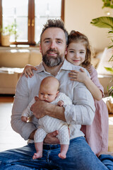 Father holding newborn baby girl, older daughter with them. New sibling. Unconditional paternal...