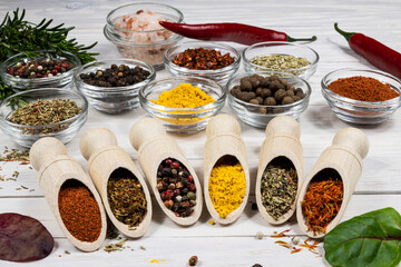 Assortment of spices and herbs close-up on wooden background.