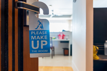 Please make up the room sign on the door. Opened door of hotel or apartment room.