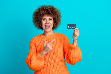 Photo of pretty excited girl indicate finger hand hold debit card empty space isolated on teal...