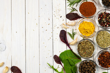Assortment of spices and herbs on white wooden background. Top view.