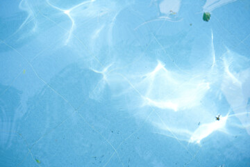 Top view of surface blue swimming pool, reflection on blue water, swirl pattern texture, blue...