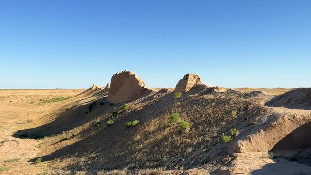 Turkestan walls of the ancient city of Sauran on a sunny day with a blue sky. Ancient buildings, fortress, ruins, ancient architecture in the settlement of Sauran. Archaeological excavations.