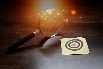 finding your goal , achievement and success , magnifying glass with goal target on paper