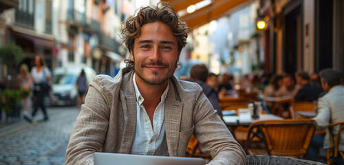 A stylish entrepreneur in a linen blazer and loafers, sitting at an outdoor cafe with a laptop on the table, smiling confidently at the camera amidst a bustling cityscape
