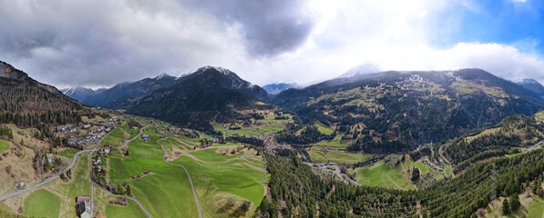 Aerial view on the highway between the mountains with the green fields in the region Albula Alvra at the Springtime. Switzerland Alps. 