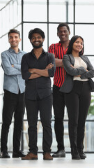 Fototapeta premium Four people stand in the office corridor and look straight ahead.
