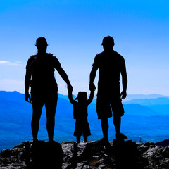 Family with Toddler on Mountain Top Silhouette Holding Hands
