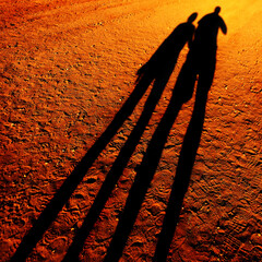 Shadow of People Holding Hands Walking on Pathway