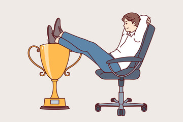 Business man received leadership cup sits in office chair, demonstrating narcissism and disdain for colleagues. Guy manager is proud of having leadership title received thanks to good work in company