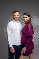 portrait of a couple, pregnant couple, pregnancy woman in a purple dress