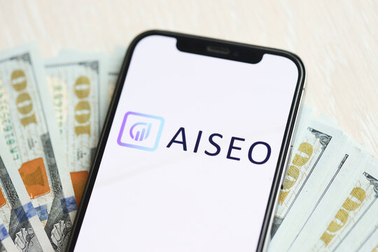 KYIV, UKRAINE - MARCH 17, 2024 AISeo logo on iPhone display screen with many hundred dollar bills. Artificial Intelligence engine