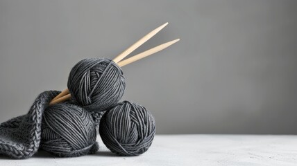 Dark yarn balls and knitting needles on gray. - obrazy, fototapety, plakaty