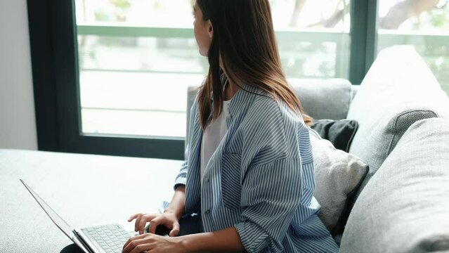 Side view concentrated young businesswoman working on computer at office or home, communicating with clients. Focused successful millennial female online business job company. Remote worker indoor