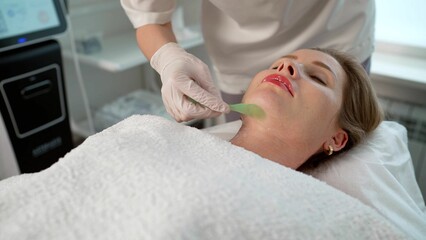 Applying gel on the face in a beauty salon. Application of cosmetic procedures using a laser...