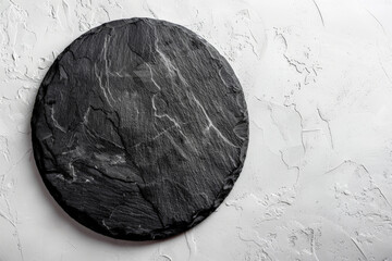 a round black slate  on white background, top view. 